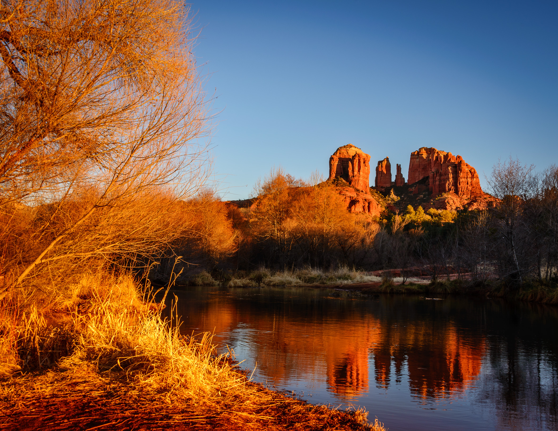 Firey December glow frames Cathedral rock and its reflection